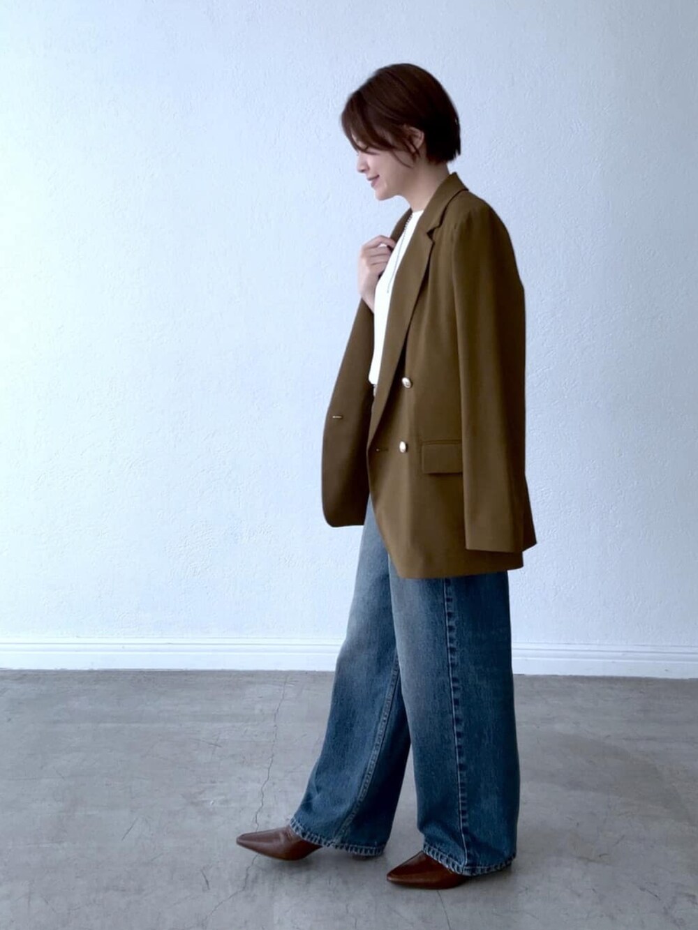 ホワイト系のシャツ/ブラウス、ブラウン系のテーラードジャケット、ブルー系のデニムパンツを着用したレディースの夏コーディネートの2枚目の写真