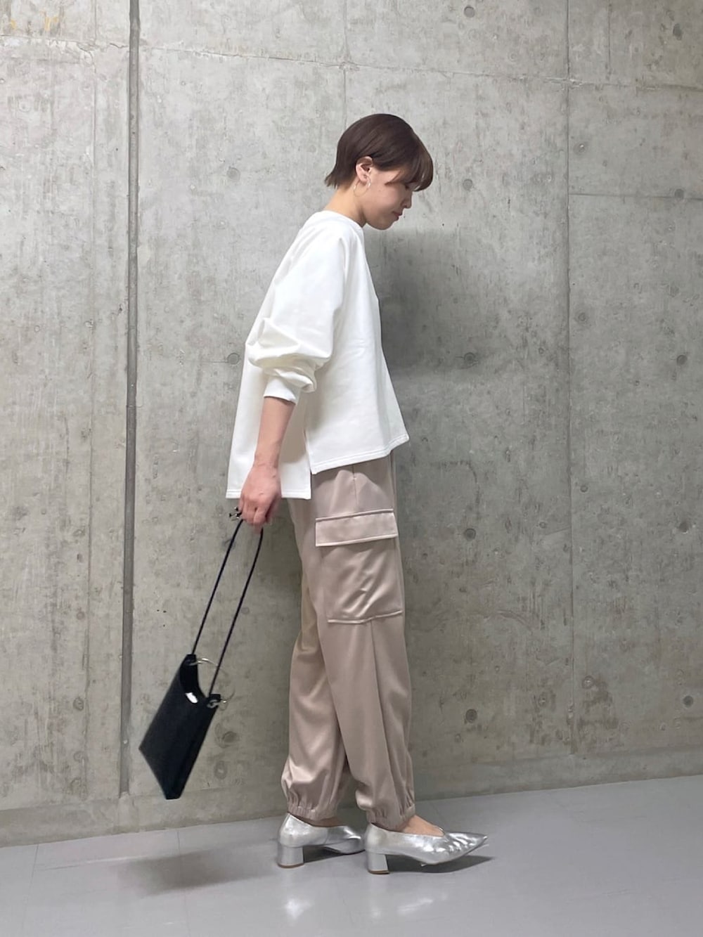 ホワイト系のスウェット、ベージュ系のカーゴパンツ、シルバー系のパンプスを着用したレディースの春コーディネートの3枚目の写真