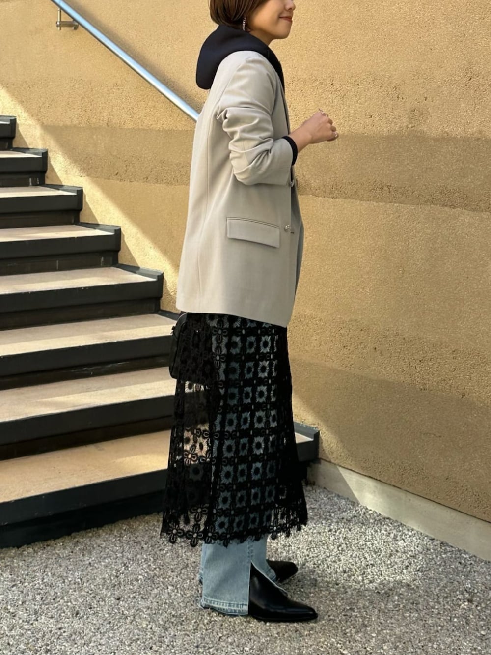 ブルー系のパーカー、ブラック系のボストンバッグ、ブルー系のデニムパンツを着用したレディースの冬コーディネートの2枚目の写真