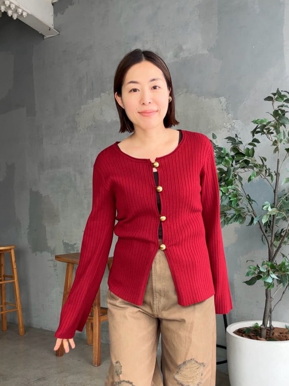 レッド系のカーディガン/ボレロ、ブラウン系のデニムパンツ、ブラウン系のハンドバッグを着用したレディースの夏コーディネートの4枚目の写真