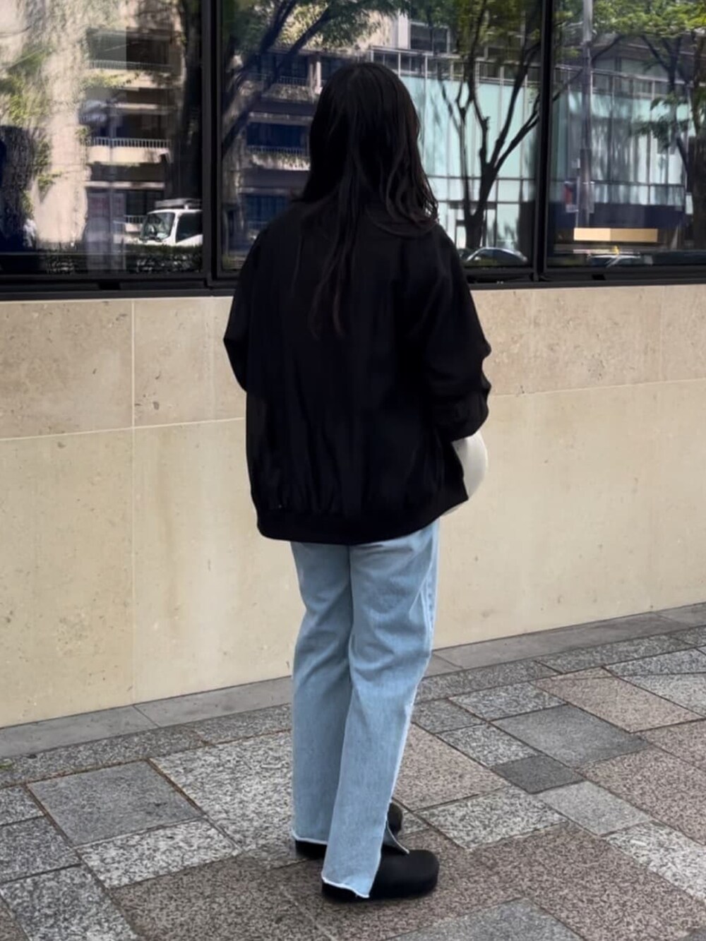 ブルー系のデニムパンツ、グレー系のTシャツ/カットソー、グリーン系のブルゾンを着用したレディースの春コーディネートの3枚目の写真