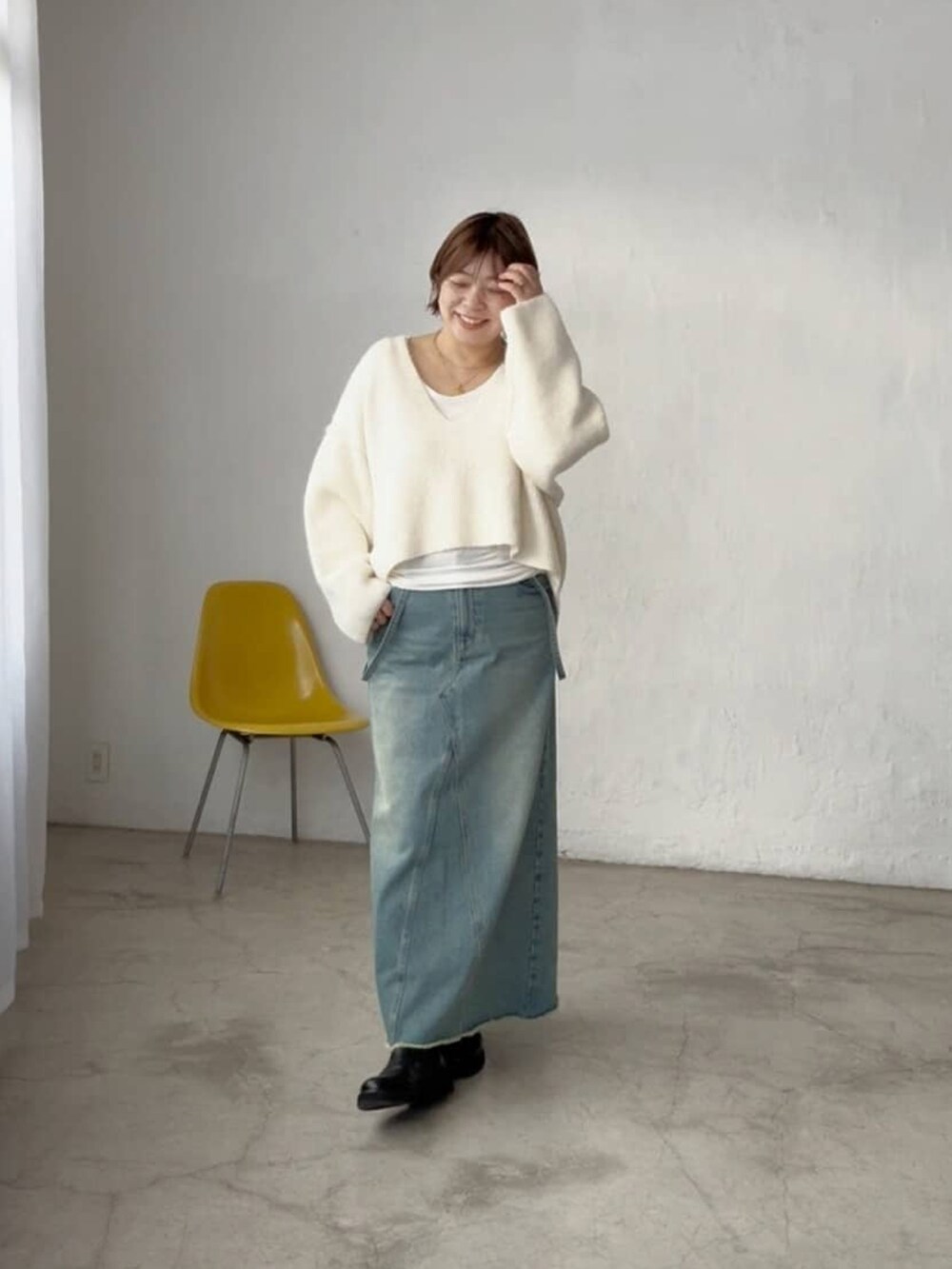 ホワイト系のニット/セーター、ブルー系のデニムスカートを着用したレディースの秋コーディネートの2枚目の写真