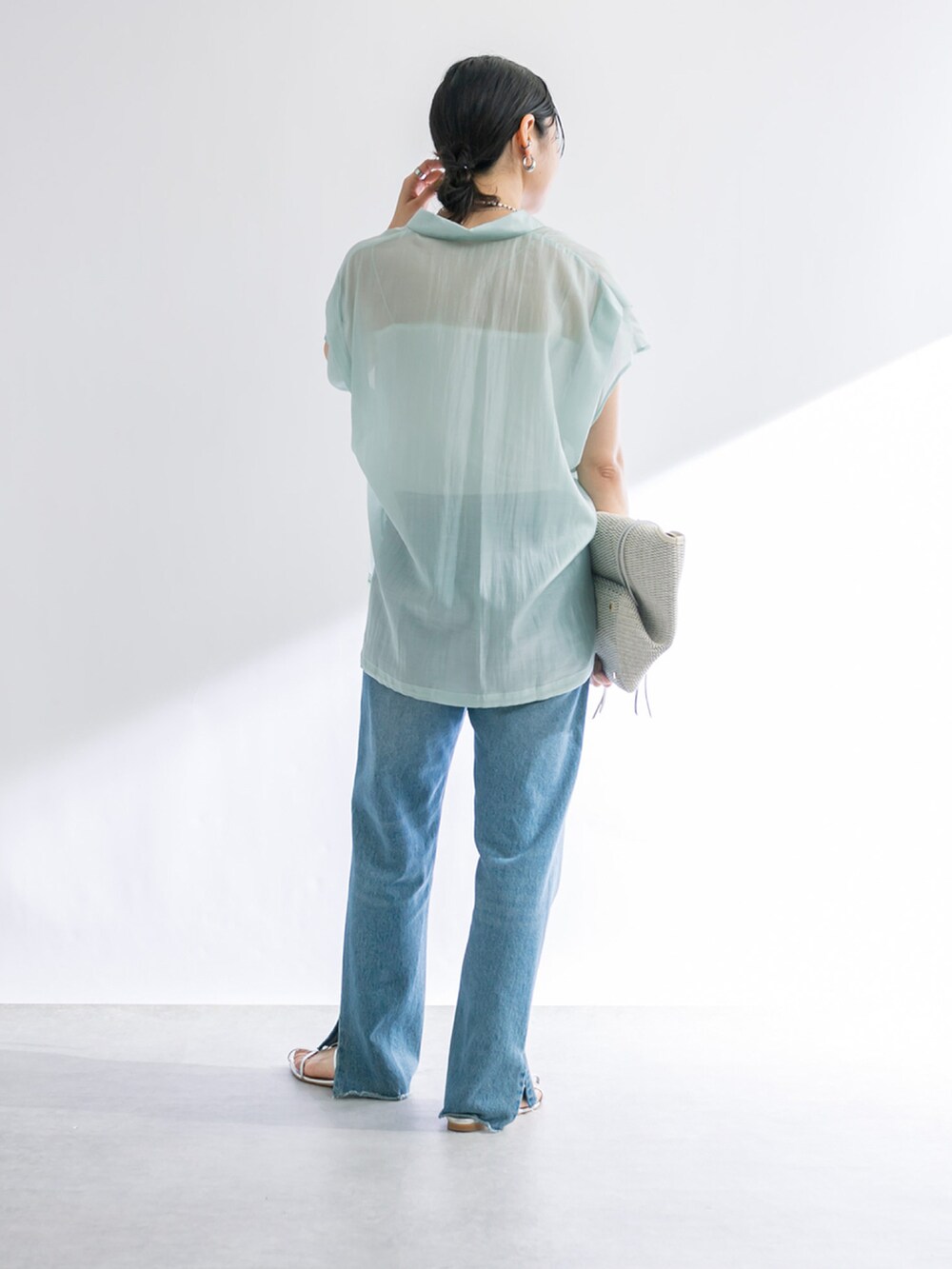 ブルー系のデニムパンツ、シルバー系のサンダル、グリーン系のシャツ/ブラウスを着用したレディースの春コーディネートの3枚目の写真