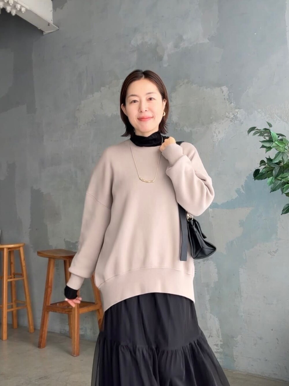 ブラック系のスカート、ブラック系のニット/セーター、ブラウン系のニット/セーターを着用したレディースの秋コーディネートの4枚目の写真