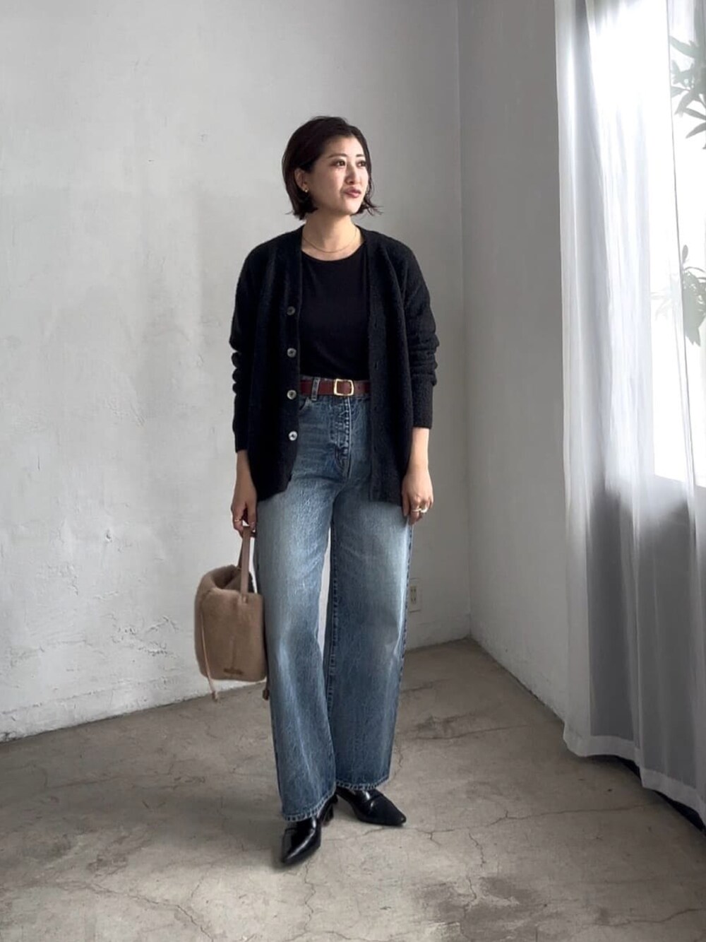 ブラック系のカーディガン/ボレロ、ブラウン系のハンドバッグ、ブラック系のローファーを着用したレディースの秋コーディネートの2枚目の写真