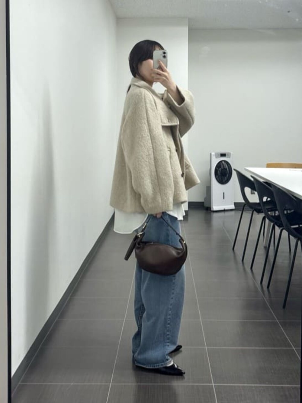 ブラウン系のショルダーバッグ、ブルー系のデニムパンツ、ホワイト系のキャミソールを着用したレディースの夏コーディネートの2枚目の写真