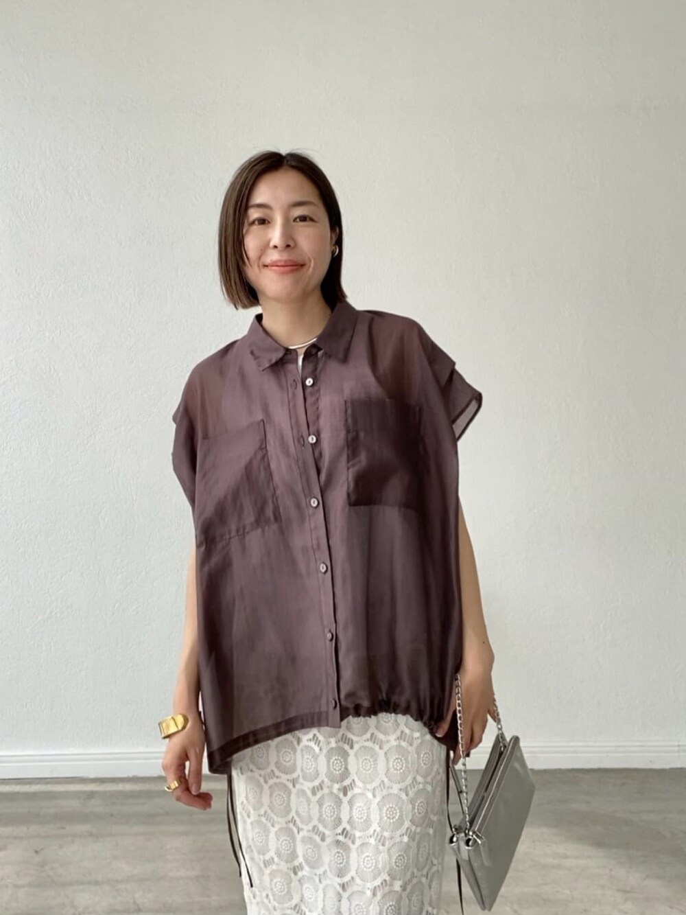 ホワイト系のスカート、シルバー系のショルダーバッグ、シルバー系のサンダルを着用したレディースの春コーディネートの5枚目の写真