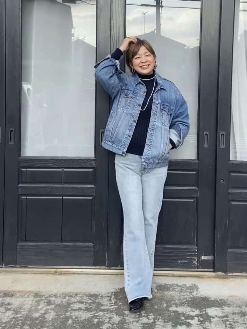 ブルー系のニット/セーター、ブルー系のデニムジャケット、ブルー系のデニムパンツを着用したレディースの冬コーディネートの2枚目の写真