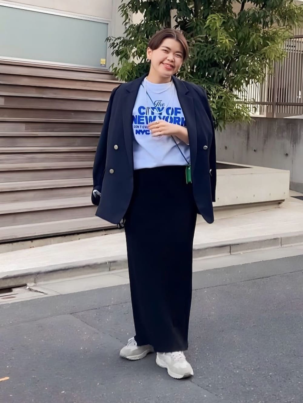 グレー系のスウェット、ベージュ系のテーラードジャケット、ブラック系のスカートを着用したレディースの冬コーディネートの2枚目の写真