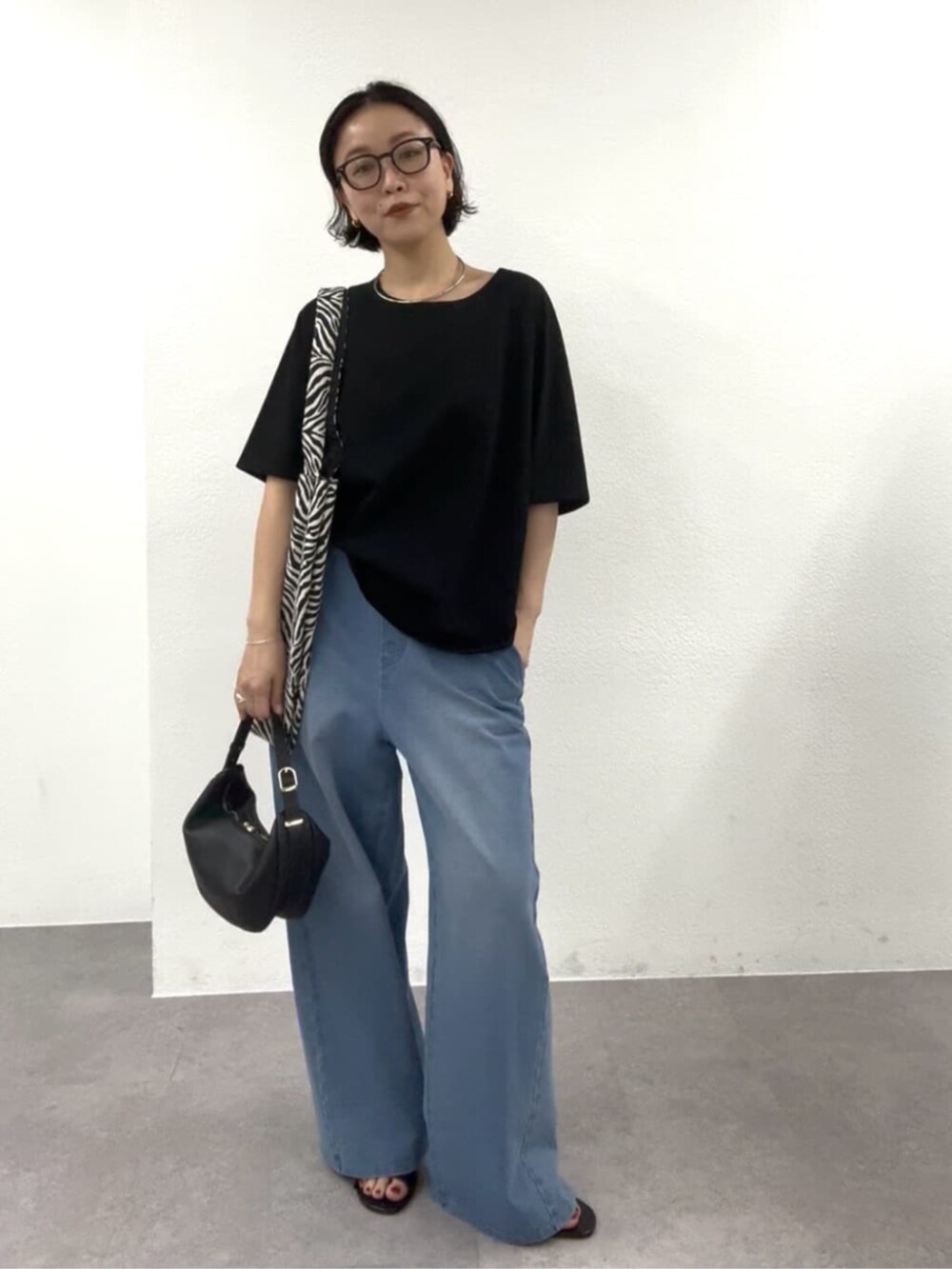 ブラック系のショルダーバッグ、ブラック系のTシャツ/カットソー、ブラック系のトートバッグを着用したレディースの春コーディネートの6枚目の写真