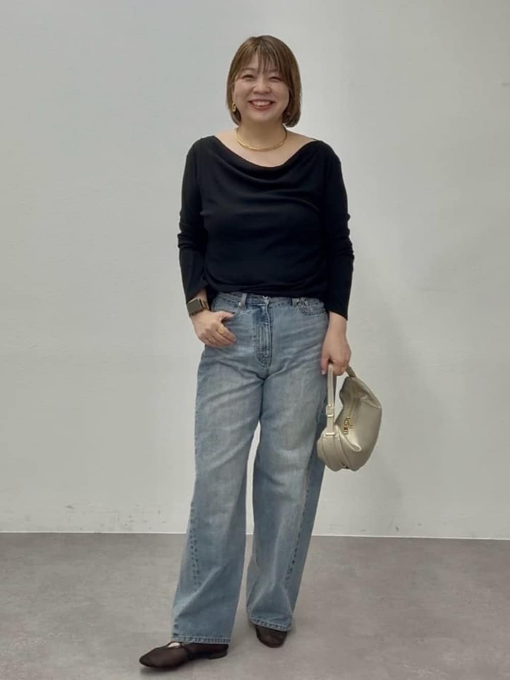 ブラック系のその他シューズ、ブラック系のTシャツ/カットソー、ブルー系のデニムパンツを着用したレディースの春コーディネートの2枚目の写真