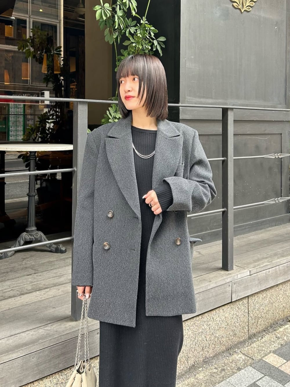 グレー系のその他アウター、ブラック系のワンピース、ブラック系のブーツを着用したレディースの冬コーディネートの3枚目の写真