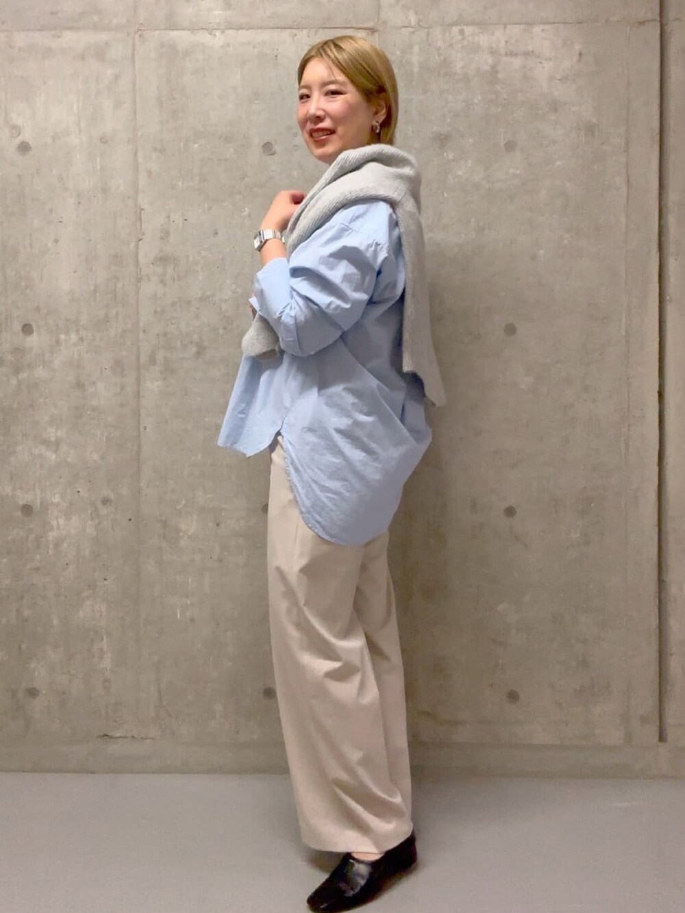 ブルー系のシャツ/ブラウス、ベージュ系のその他パンツ、グレー系のニット/セーターを着用したレディースの冬コーディネートの2枚目の写真