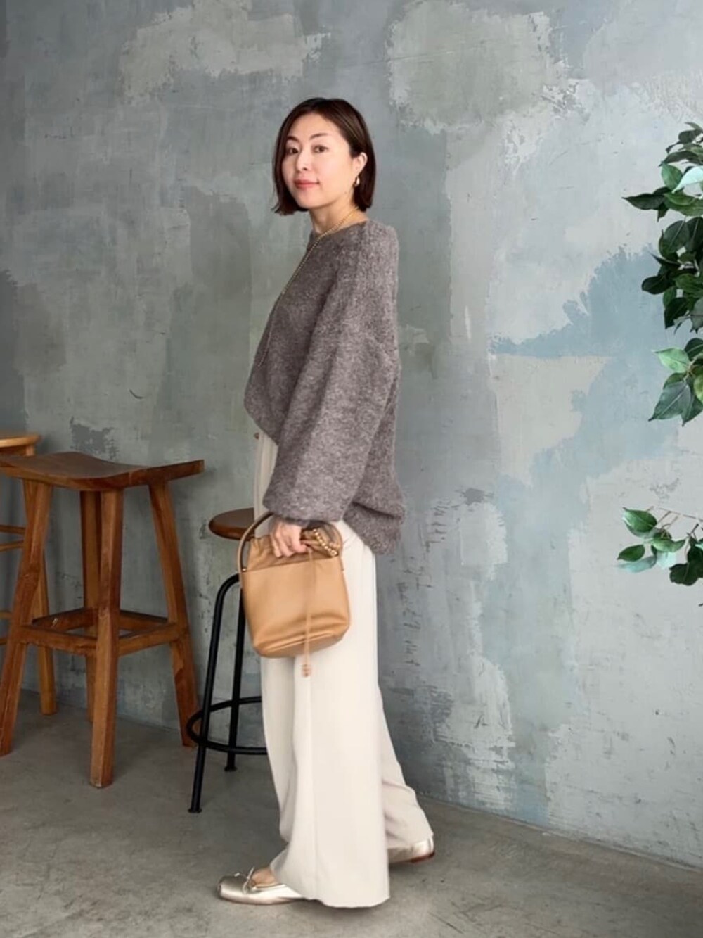 ブラウン系のニット/セーター、ベージュ系のパンツ、イエロー系のハンドバッグを着用したレディースの秋コーディネートの2枚目の写真