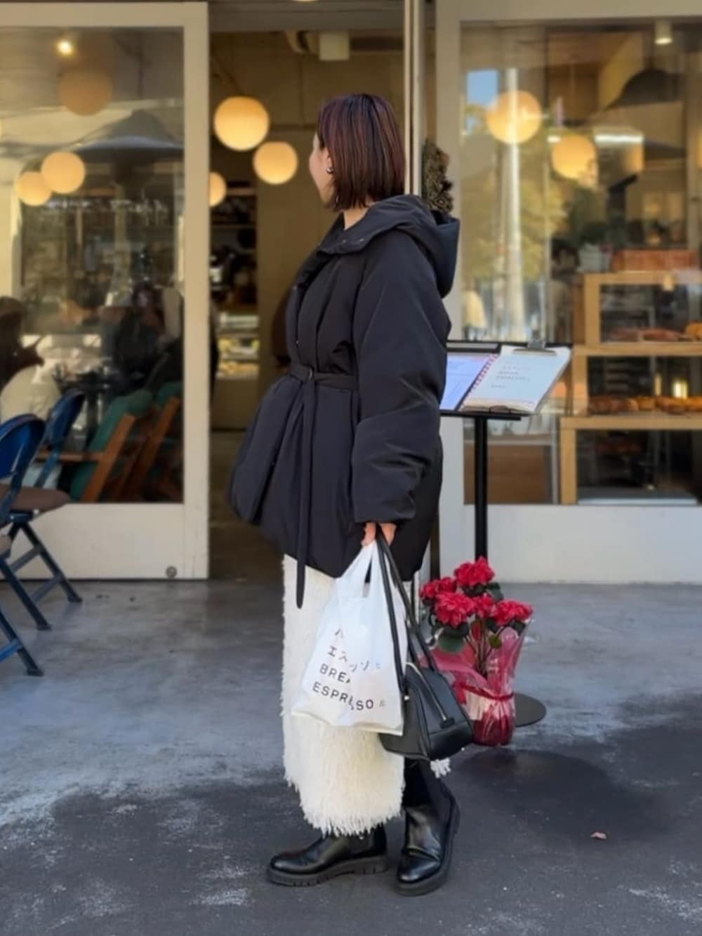 ブラック系のダウンジャケット/コート、ホワイト系のスカートを着用したレディースの冬コーディネートの2枚目の写真