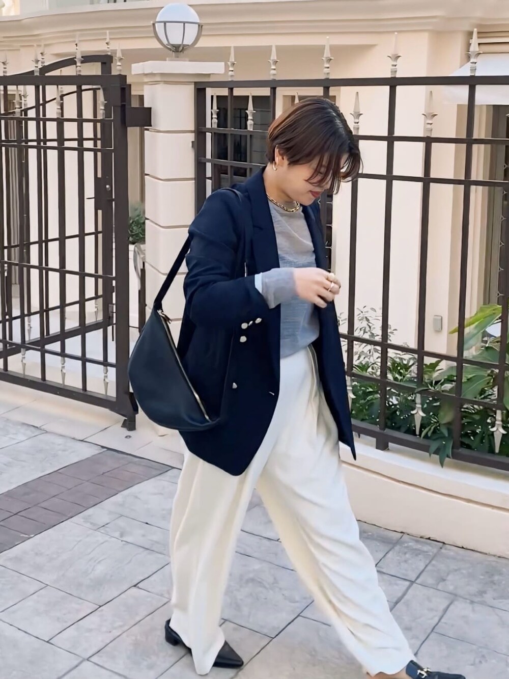 ブルー系のテーラードジャケット、グレー系のニット/セーター、ホワイト系のスラックスを着用したレディースの冬コーディネートの2枚目の写真