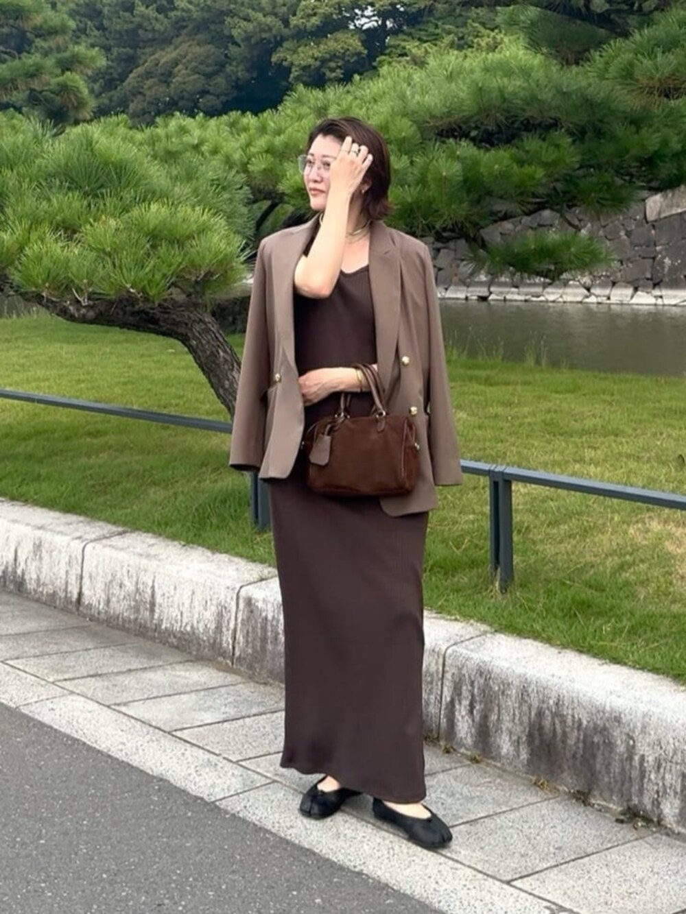 ブラウン系のテーラードジャケット、ブラウン系のワンピース、ゴールド系のチョーカーを着用したレディースの秋コーディネートの3枚目の写真