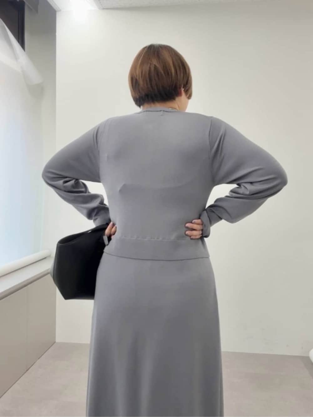 ブラック系のスラックス、ブラック系のハンドバッグ、ブラック系のその他シューズを着用したレディースの秋コーディネートの5枚目の写真