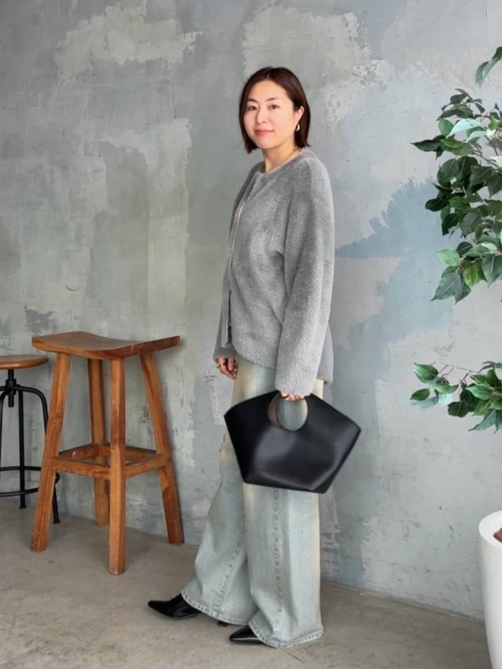 グレー系のカーディガン/ボレロ、ブルー系のデニムパンツ、ブラック系のローファーを着用したレディースの秋コーディネートの4枚目の写真