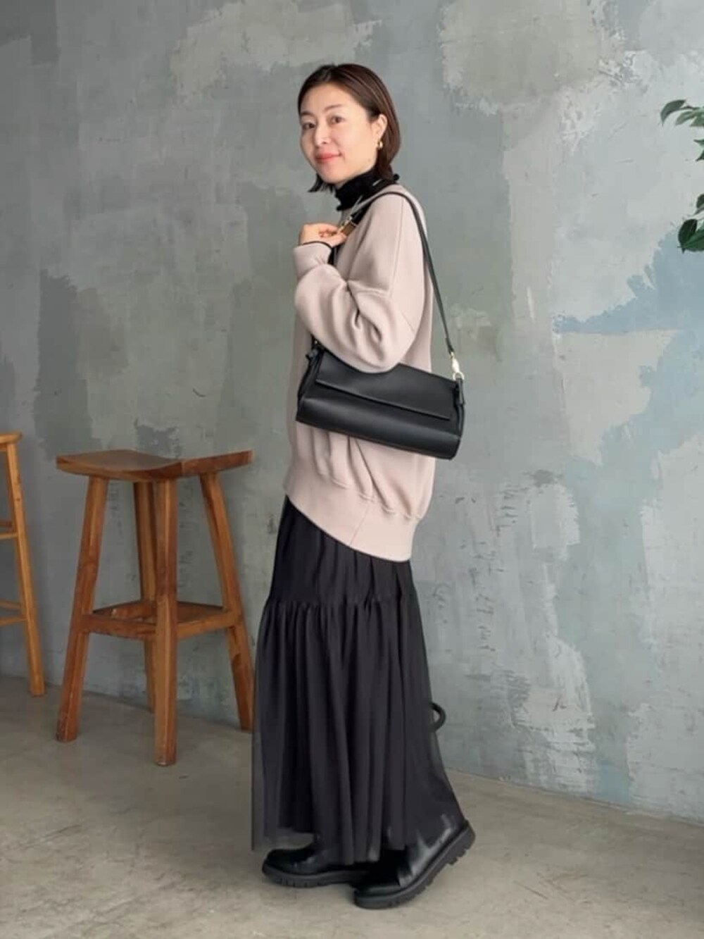 ブラック系のスカート、ブラック系のニット/セーター、ブラウン系のニット/セーターを着用したレディースの秋コーディネートの2枚目の写真