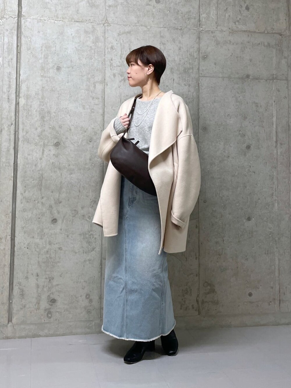 ベージュ系のその他アウター、ブルー系のデニムスカート、グレー系のニット/セーターを着用したレディースの冬コーディネートの4枚目の写真