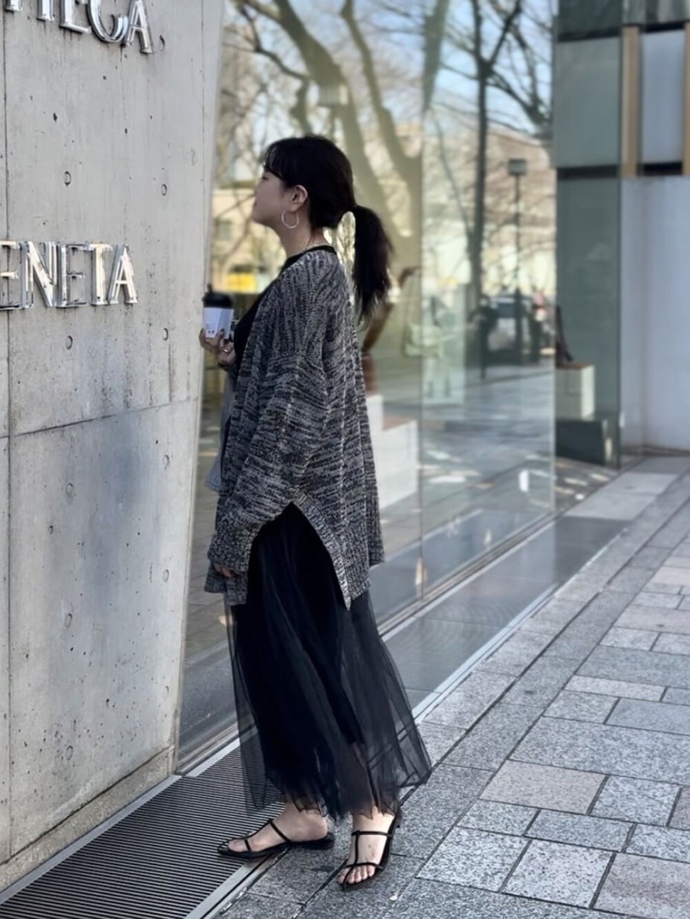 ブラック系のTシャツ/カットソー、グレー系のカーディガン/ボレロ、ブラック系のスカートを着用したレディースの冬コーディネートの3枚目の写真