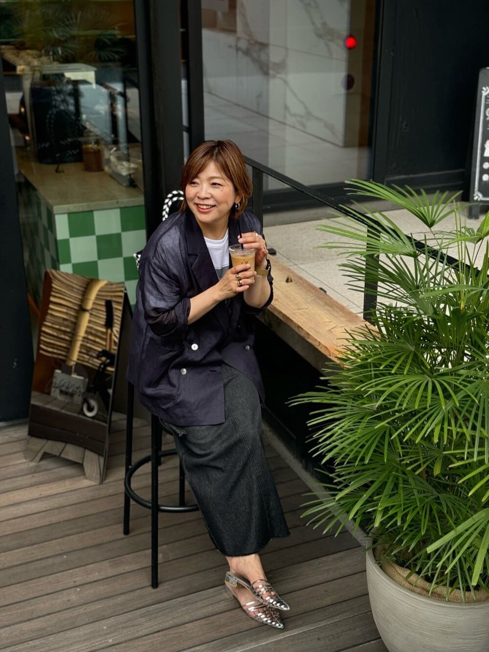 ブルー系のテーラードジャケット、ブルー系のデニムスカート、シルバー系のサンダルを着用したレディースの夏コーディネートの5枚目の写真