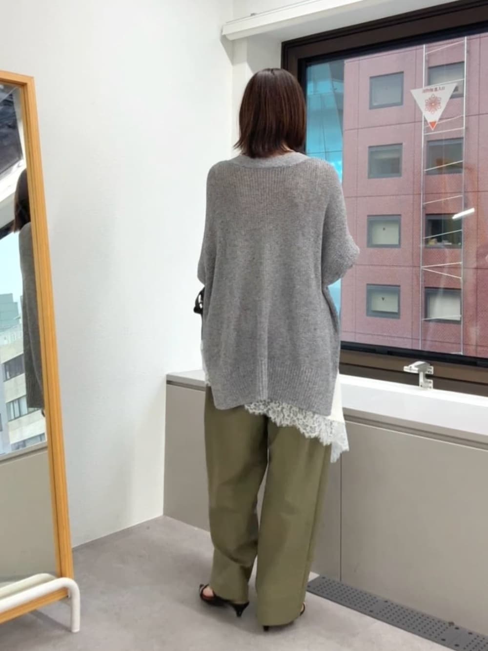 ブラック系のサンダル、ホワイト系のキャミソール、ブラック系のショルダーバッグを着用したレディースの春コーディネートの3枚目の写真