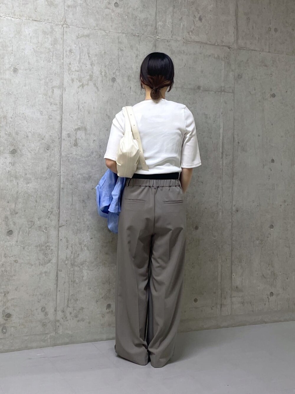 ホワイト系のTシャツ/カットソー、グレー系のスラックスを着用したレディースの春コーディネートの3枚目の写真