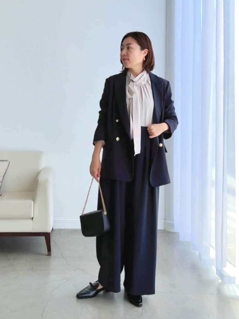 ベージュ系のシャツ/ブラウス、ブルー系のテーラードジャケット、ブルー系のスラックスを着用したレディースの冬コーディネートの3枚目の写真