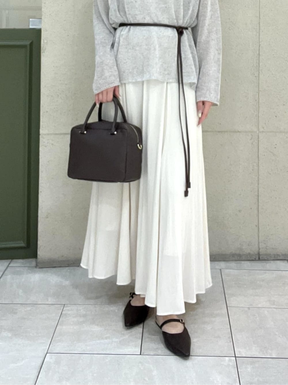 ブラウン系のその他シューズ、ブラウン系のボストンバッグ、ベージュ系のスカートを着用したレディースの春コーディネートの4枚目の写真