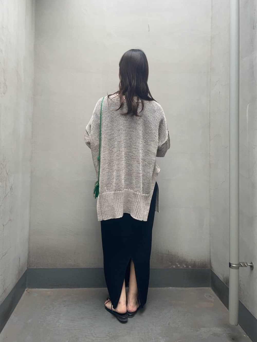 ブラック系のワンピース、グレー系のカーディガン/ボレロ、ブラック系のサンダルを着用したレディースの春コーディネートの3枚目の写真