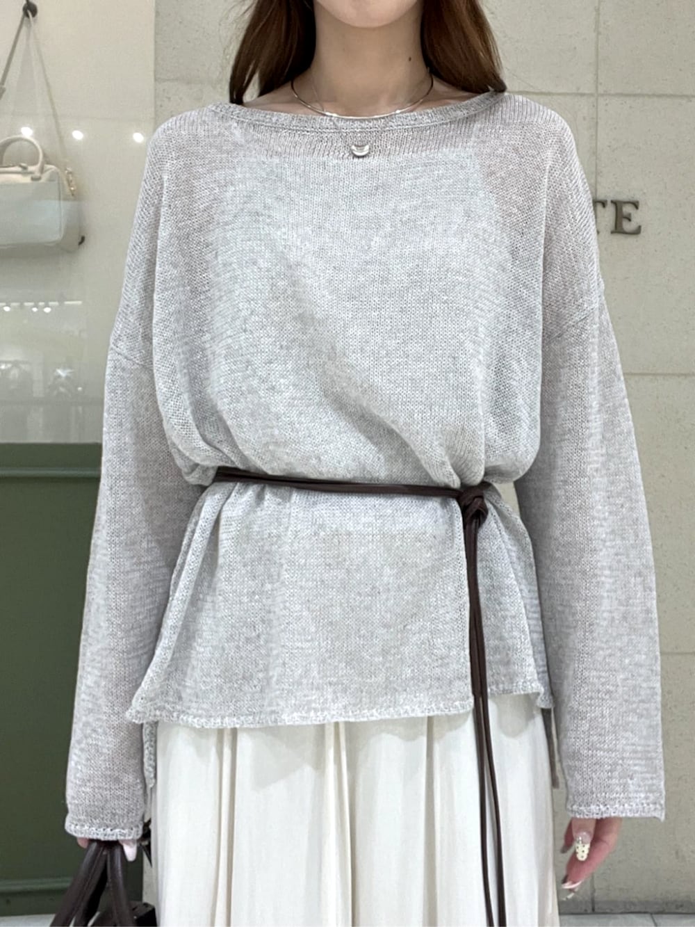 ブラウン系のその他シューズ、ブラウン系のボストンバッグ、ベージュ系のスカートを着用したレディースの春コーディネートの3枚目の写真