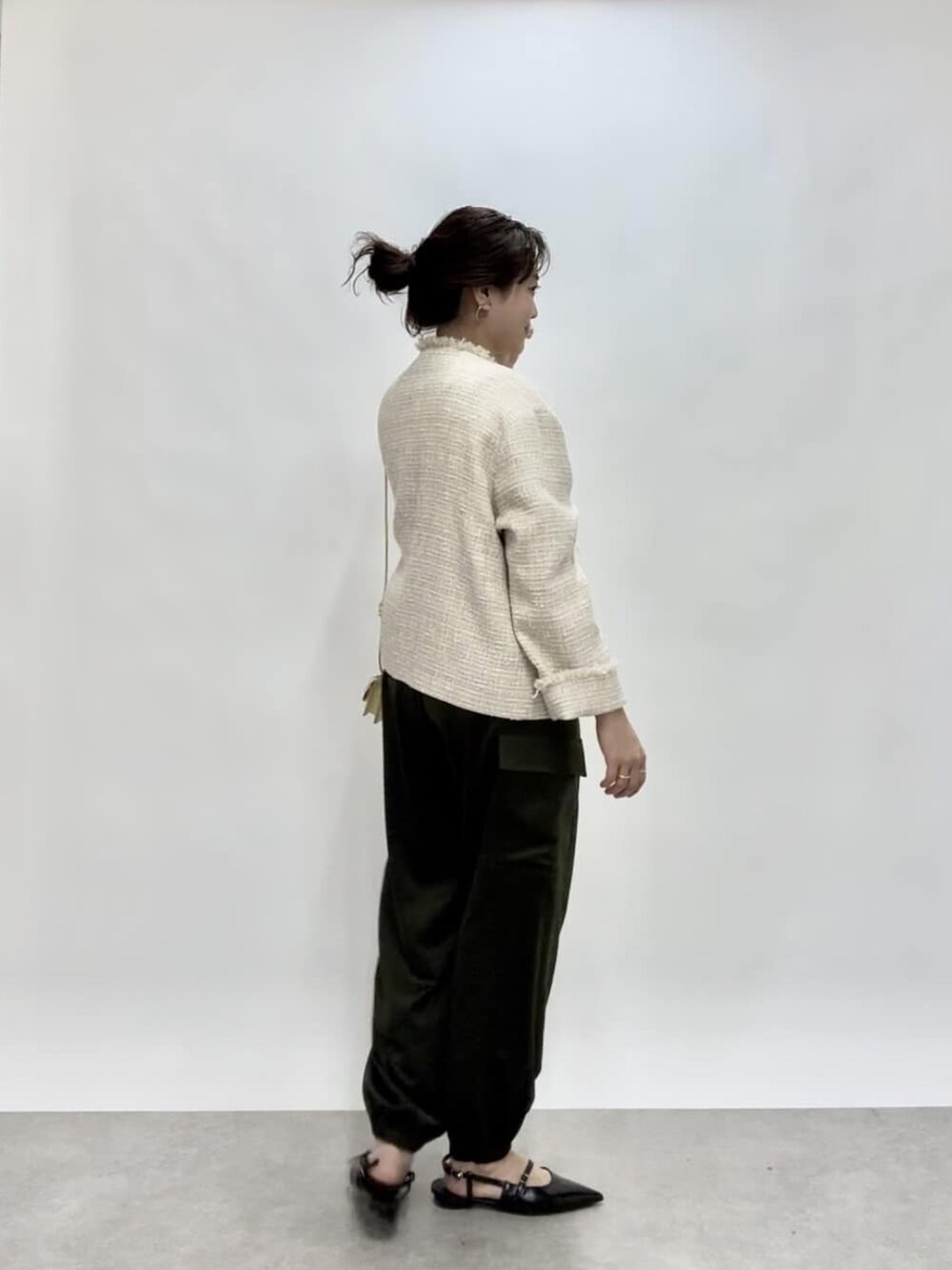 ベージュ系のノーカラージャケット、グリーン系のカーゴパンツ、ブラック系のパンプスを着用したレディースの冬コーディネートの4枚目の写真