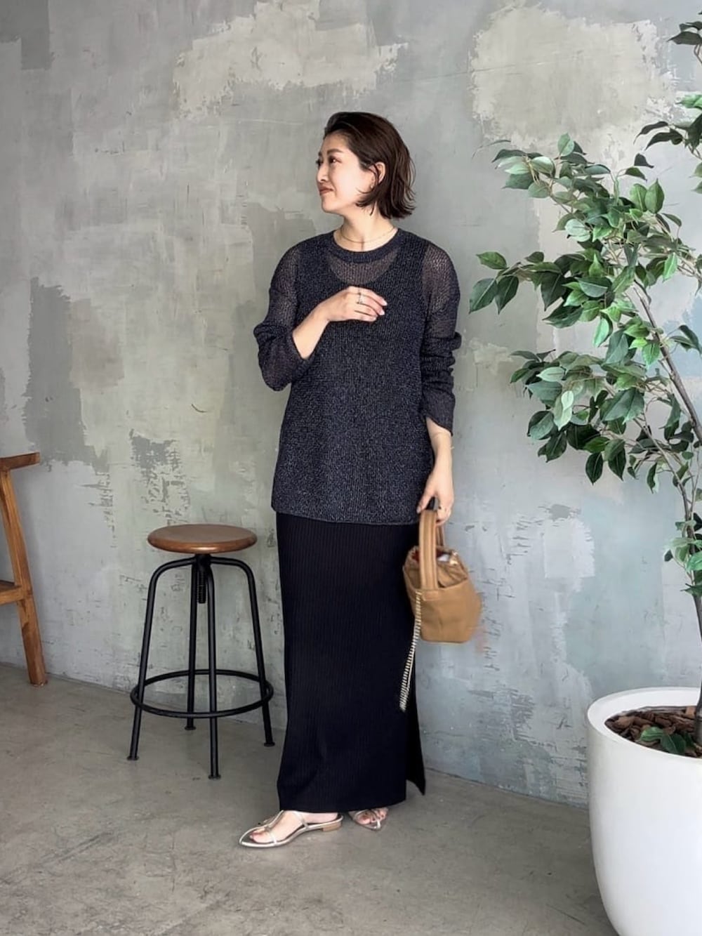 ブルー系のニット/セーター、ブラック系のワンピース、イエロー系のハンドバッグを着用したレディースの夏コーディネートの2枚目の写真