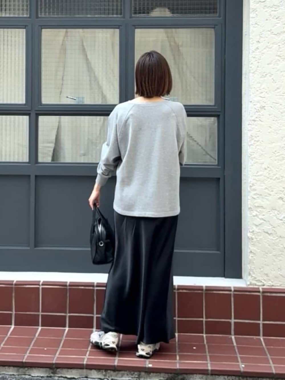 ブラック系のボストンバッグ、ブラック系のスカート、グレー系のテーラードジャケットを着用したレディースの冬コーディネートの4枚目の写真