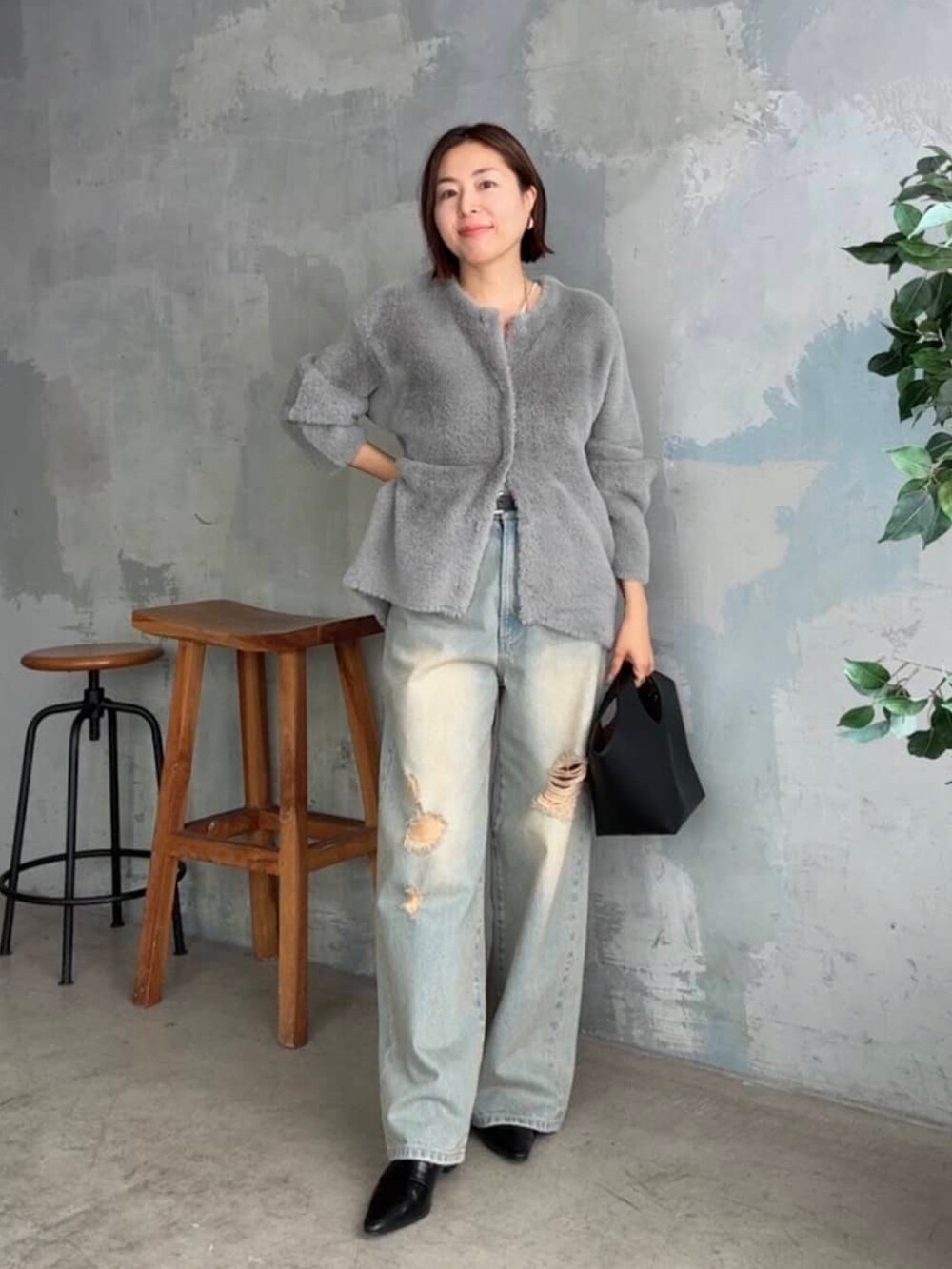 グレー系のカーディガン/ボレロ、ブルー系のデニムパンツ、ブラック系のローファーを着用したレディースの秋コーディネートの2枚目の写真