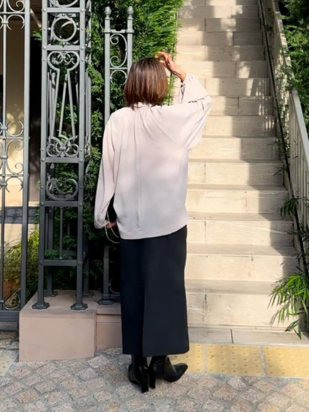 ベージュ系のシャツ/ブラウス、ブルー系のスカート、ブラック系のブーツを着用したレディースの冬コーディネートの3枚目の写真