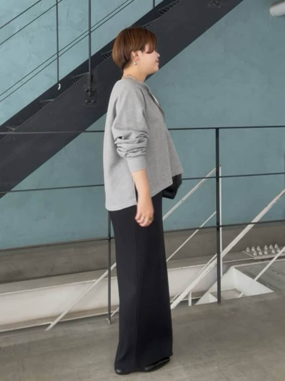 グレー系のスウェット、ブラック系のワンピース、シルバー系のチョーカーを着用したレディースの春コーディネートの3枚目の写真