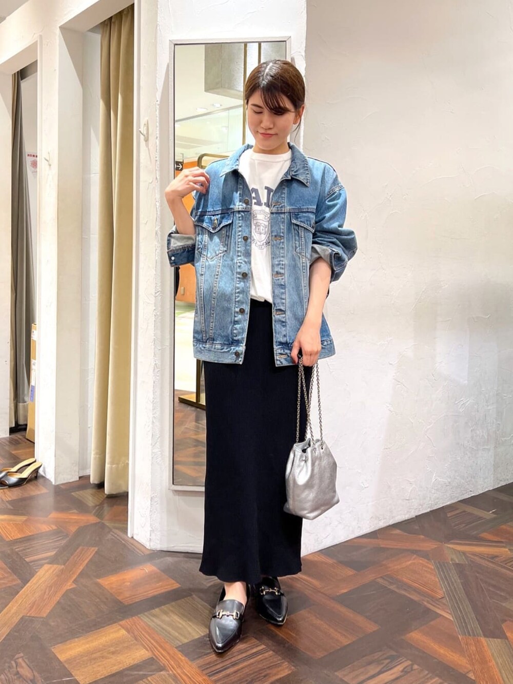 シルバー系のショルダーバッグ、ブラック系のスカート、ブラック系のローファーを着用したレディースの秋コーディネートの2枚目の写真