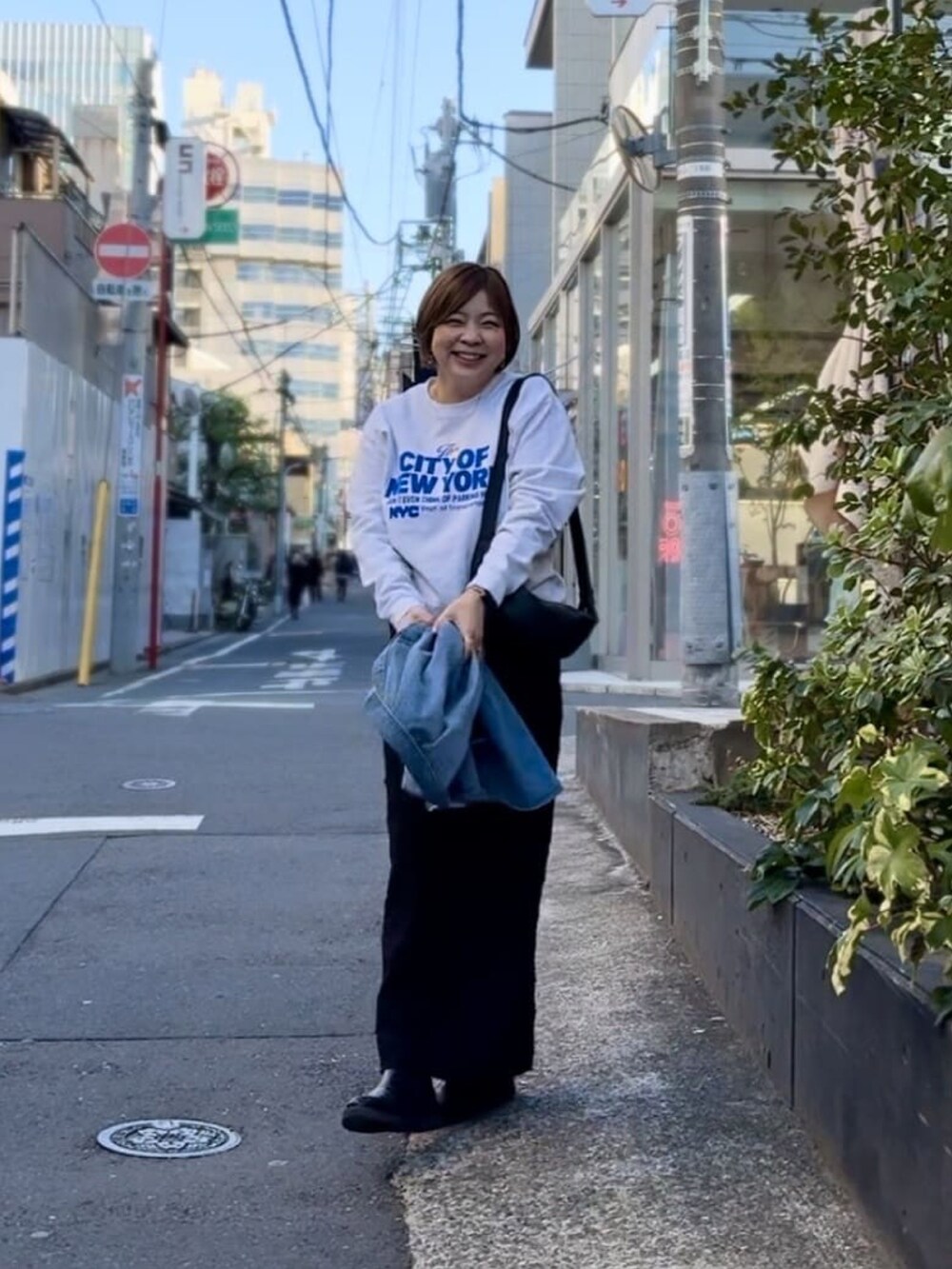 グレー系のスウェット、ブラック系のスカート、ブラック系のブーツを着用したレディースの冬コーディネートの2枚目の写真