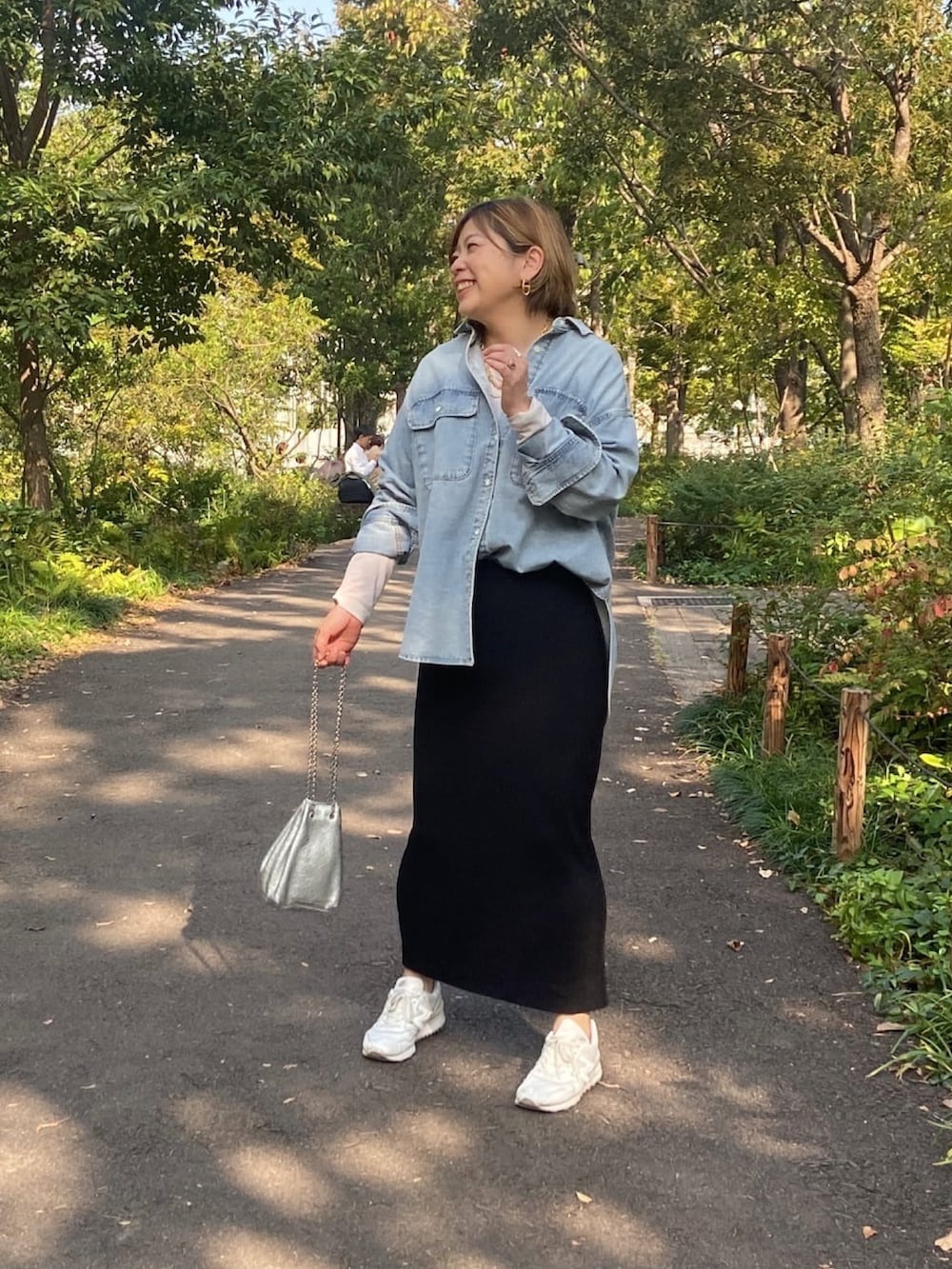 ブルー系のシャツ/ブラウス、ブラック系のスカート、シルバー系のショルダーバッグを着用したレディースの冬コーディネートの2枚目の写真