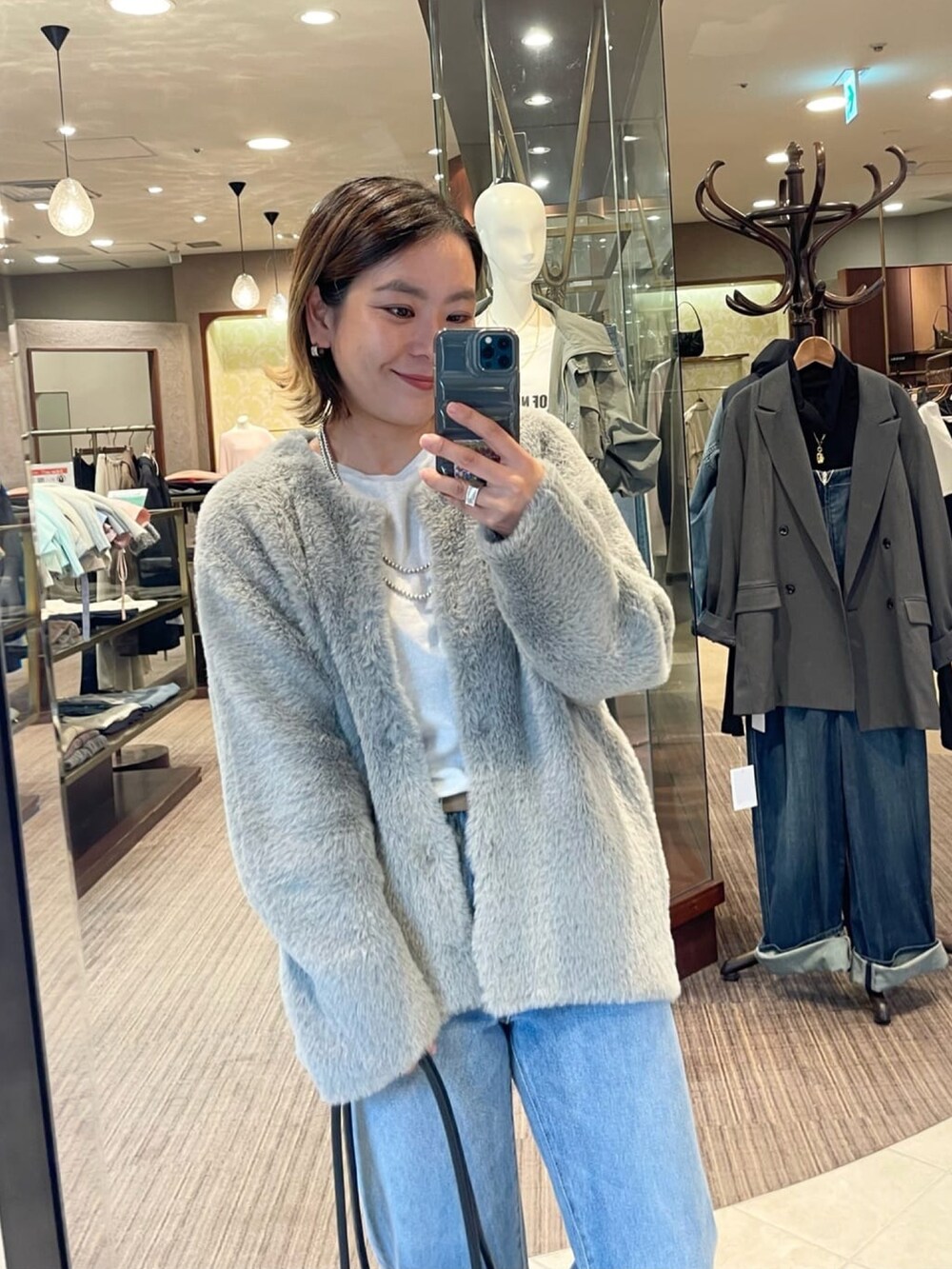 グレー系のカーディガン/ボレロ、ブルー系のデニムパンツを着用したレディースの秋コーディネートの3枚目の写真