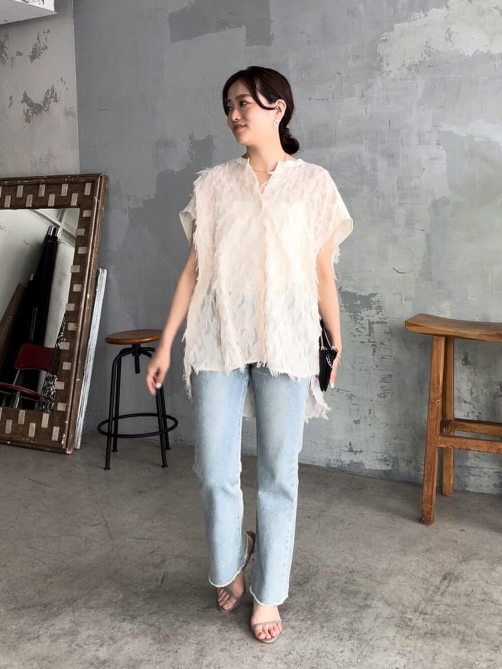 ホワイト系のシャツ/ブラウス、ブラック系のショルダーバッグ、ブルー系のデニムパンツを着用したレディースの夏コーディネートの2枚目の写真
