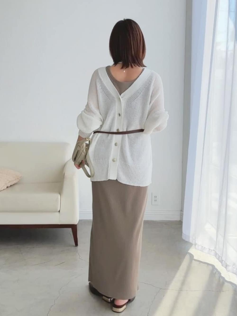 ブラウン系のその他シューズ、ゴールド系のショルダーバッグ、ホワイト系のカーディガン/ボレロを着用したレディースの春コーディネートの3枚目の写真