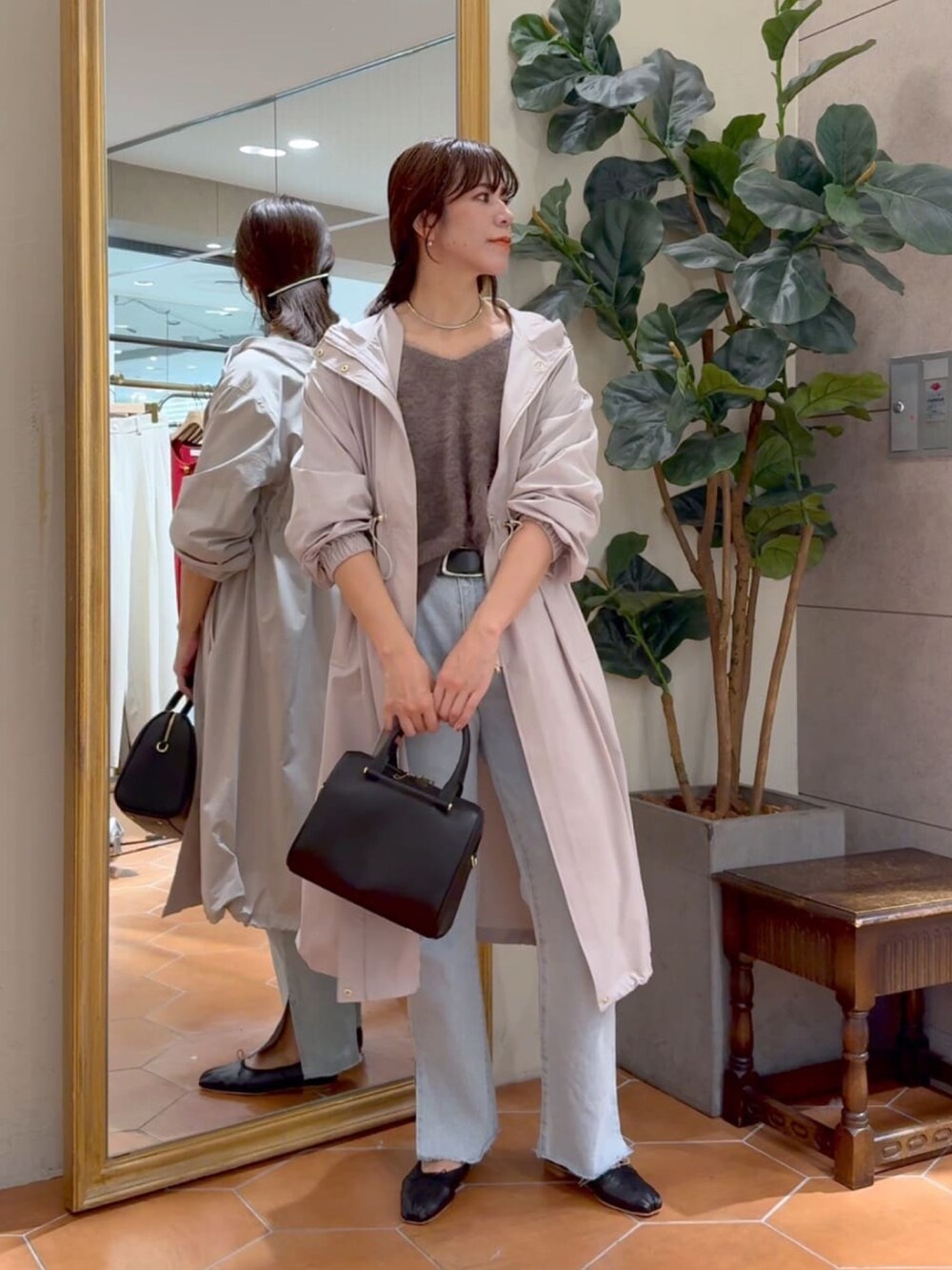 ブラウン系のニット/セーター、ベージュ系のモッズコート、ブラック系のボストンバッグを着用したレディースの秋コーディネートの4枚目の写真