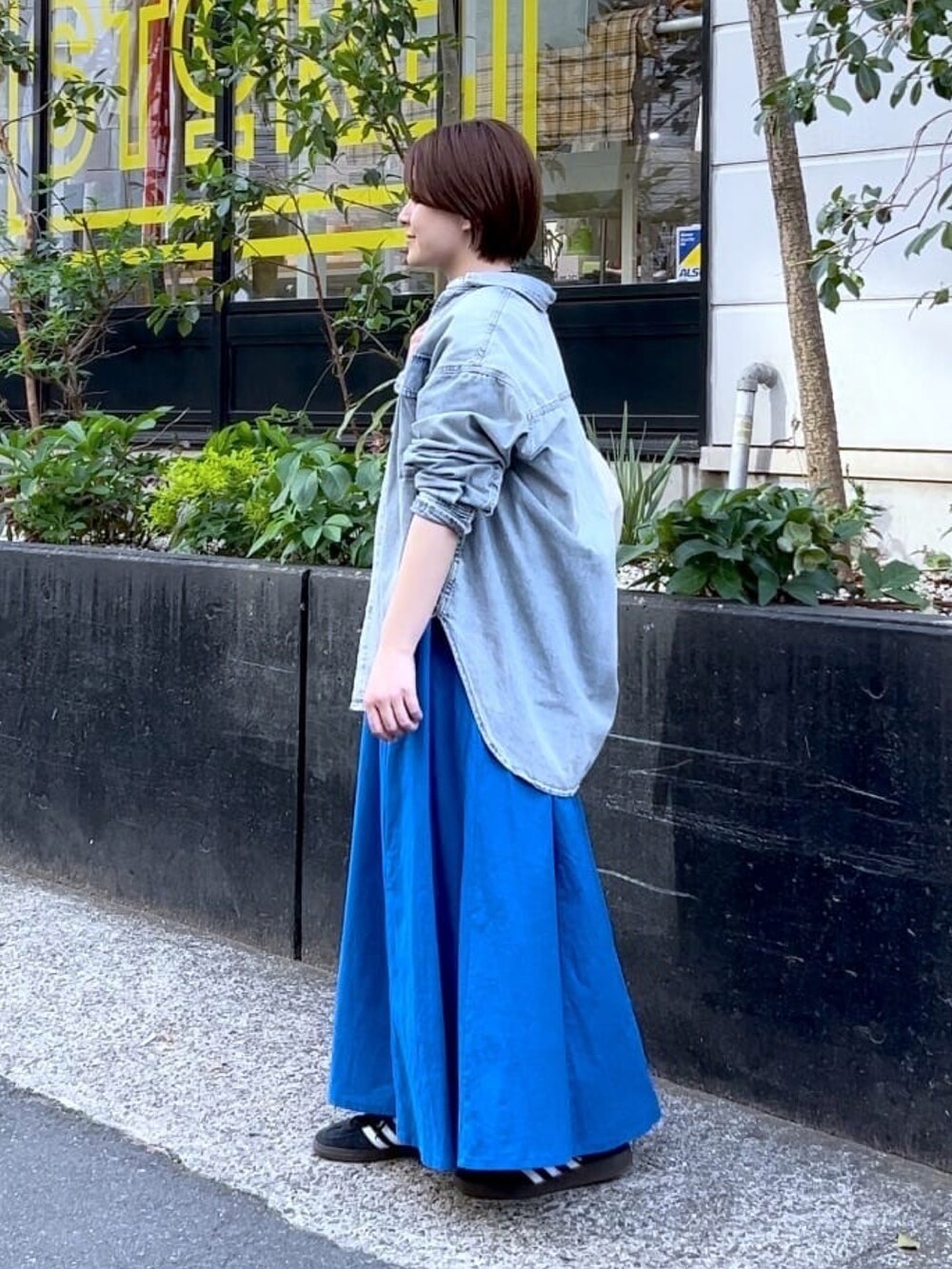 ブルー系のシャツ/ブラウス、ブルー系のワンピース、シルバー系のネックレスを着用したレディースの春コーディネートの3枚目の写真