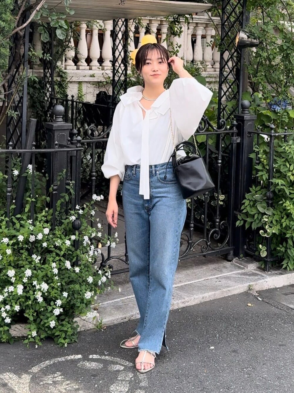 ホワイト系のシャツ/ブラウス、ブルー系のデニムパンツ、ブラック系のハンドバッグを着用したレディースの夏コーディネートの2枚目の写真