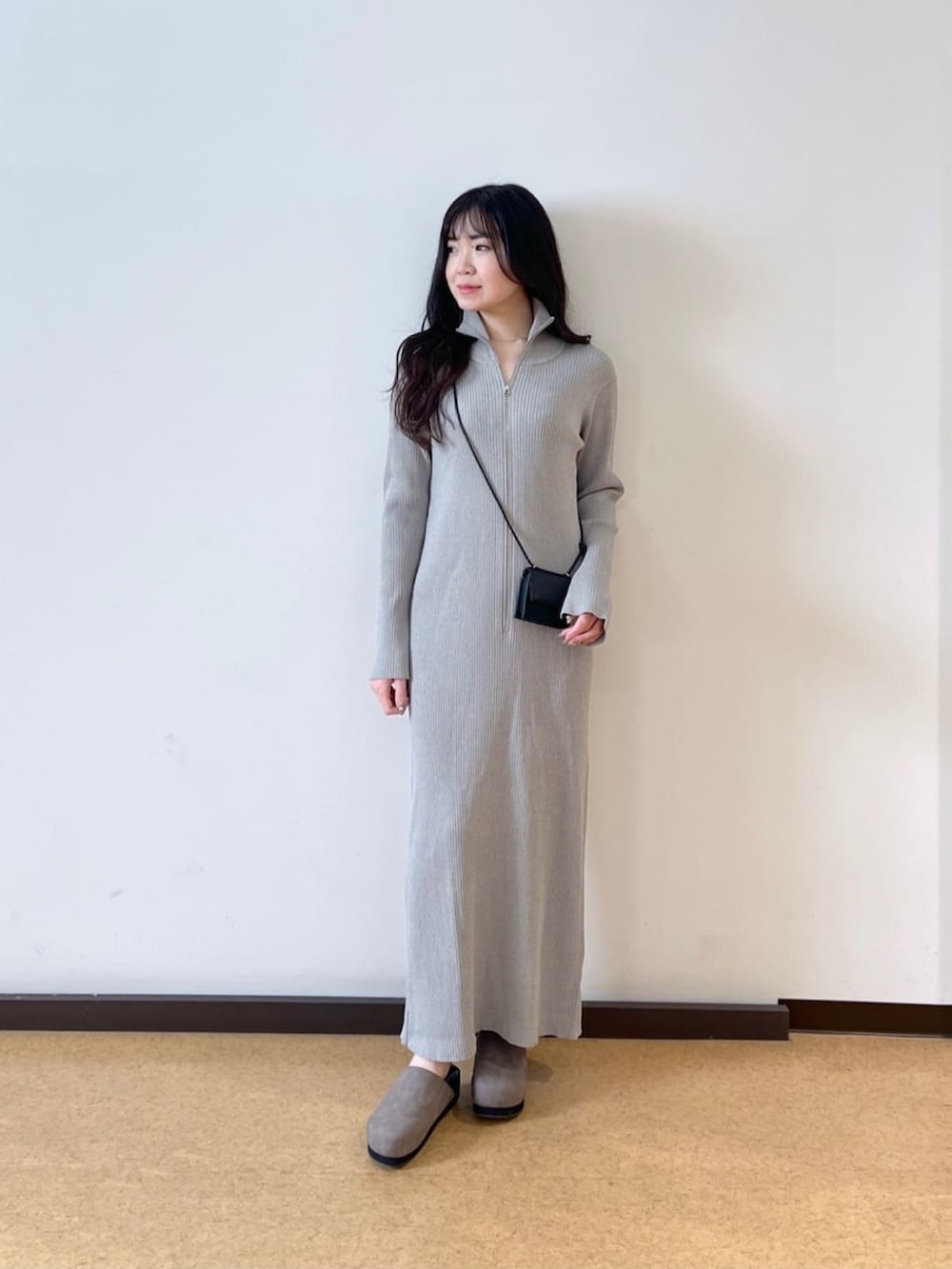 ブラック系のマウンテンパーカー、グレー系のワンピース、ブラック系のショルダーバッグを着用したレディースの春コーディネートの2枚目の写真