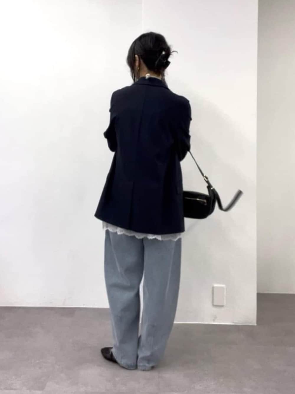 ホワイト系のキャミソール、ブルー系のデニムパンツ、ブラック系のその他シューズを着用したレディースの冬コーディネートの3枚目の写真